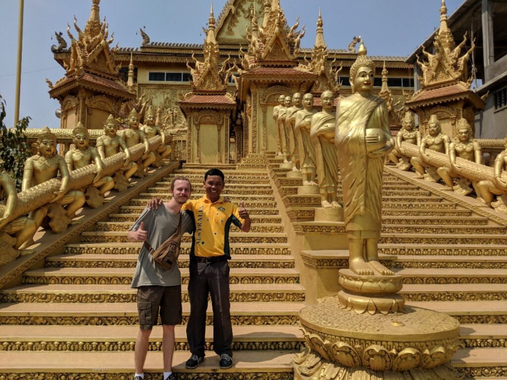 Local guide Bunna smiling with his tuk-tuk in Phnom Penh, ready for personalized tours and transfers.